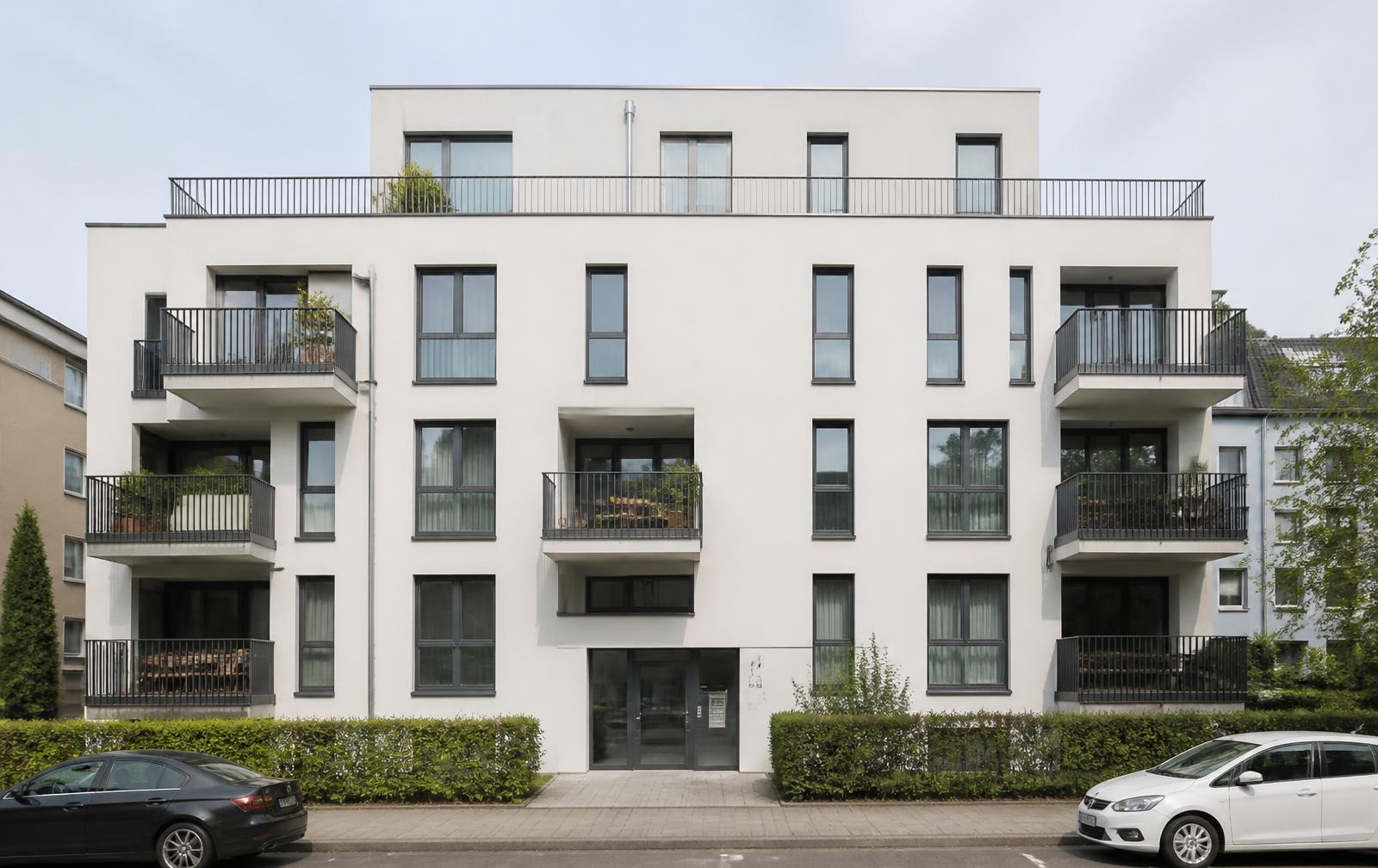 Modernes Mehrfamilienhaus mit heller Fassade als Referenz für TGA-Fachplanung